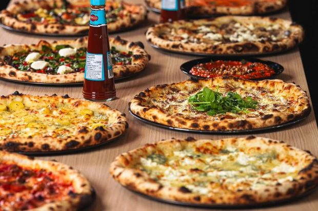 A lavish spread of various Ignite Pizzeria stone-fired pizzas ready for catering in Vancouver