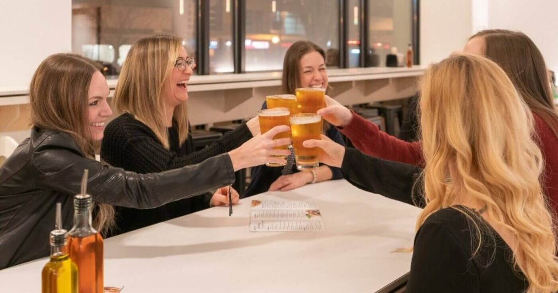 women cheering with craft beer at ignite pizzeria mount pleasant