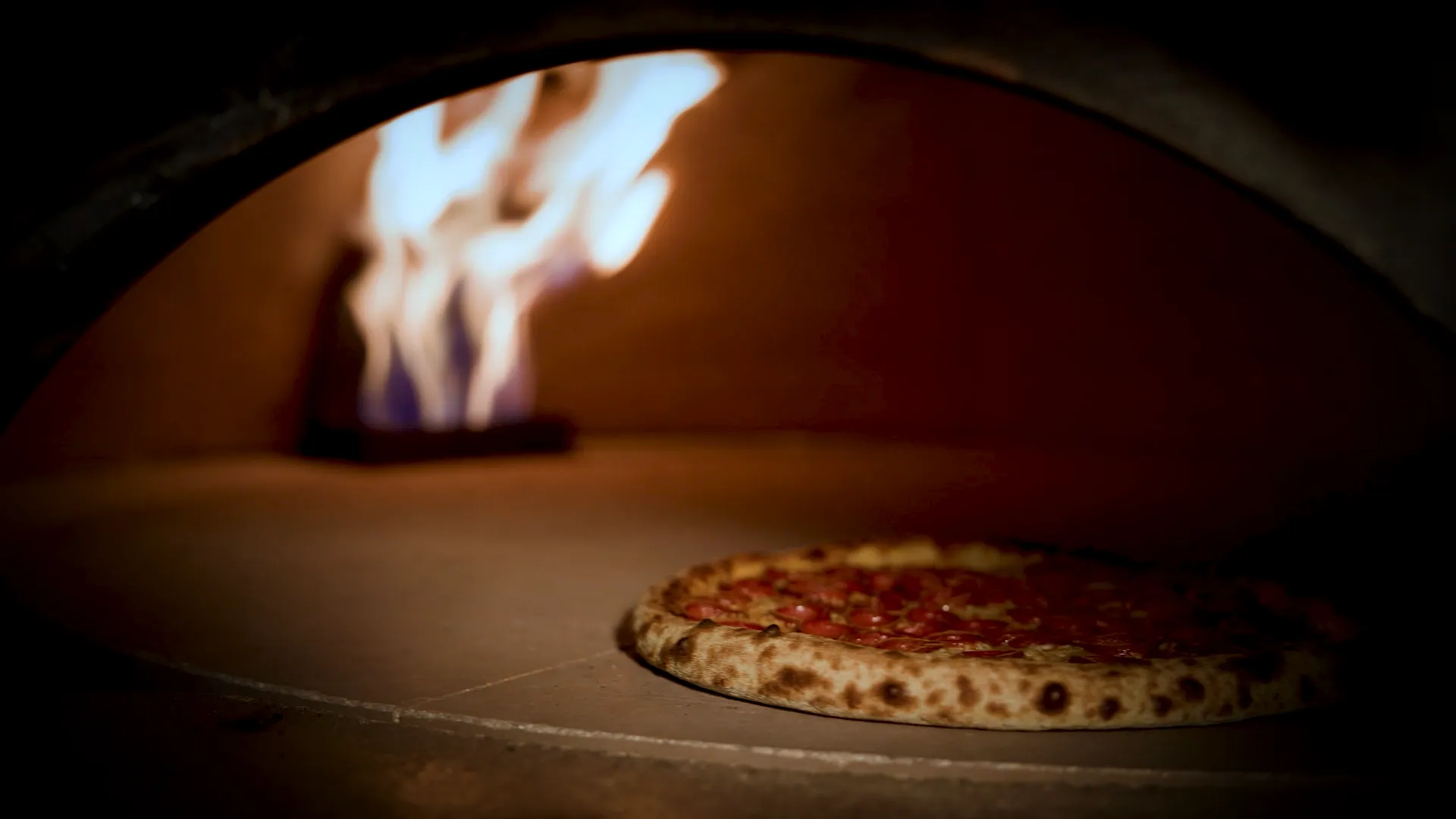 Pizza baking in Ignite's stone oven