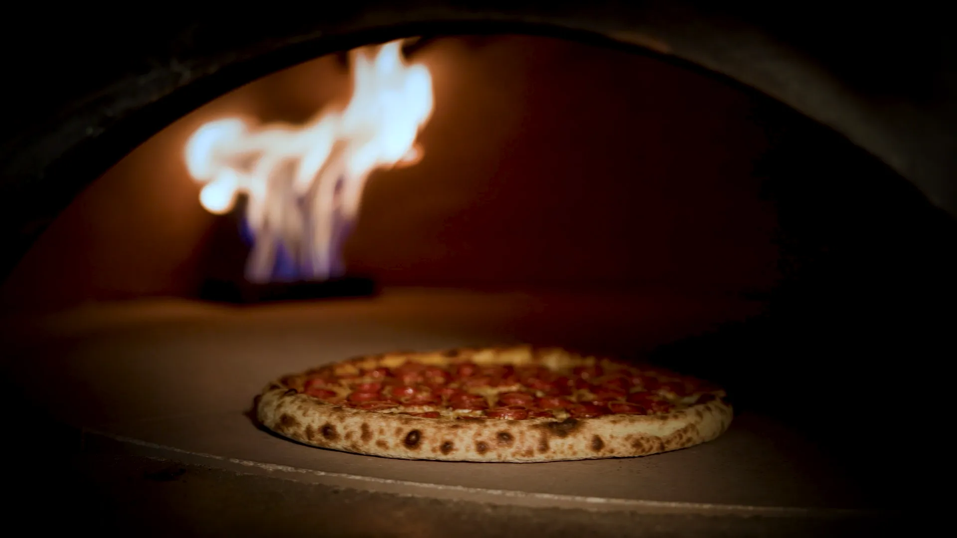 Pizza baking in Ignite's stone oven